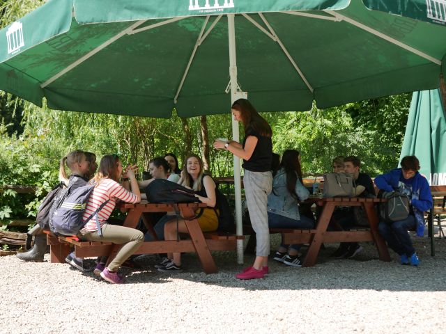Wyjazd do arboretum Bolestraszyce, uczestnicy pod wielkim zielonym parasolem ogrodowym.
