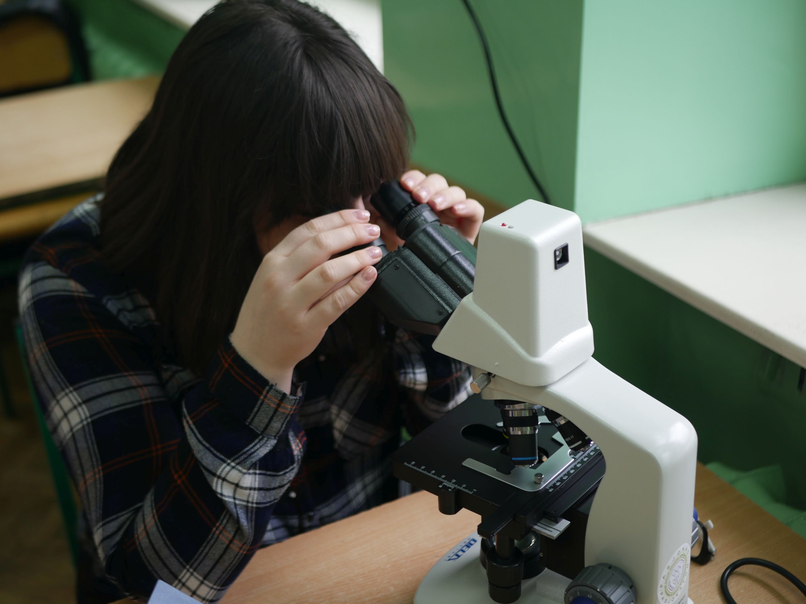 Dziewczyna patrząca przez mikroskop.