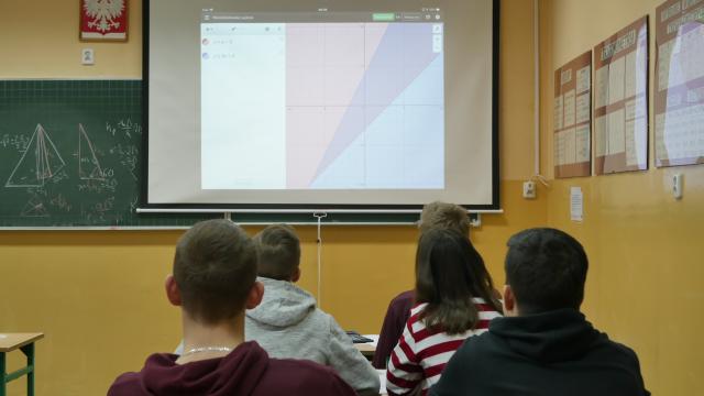 Uczniowie wpatrzeni w ekran rzutnika.