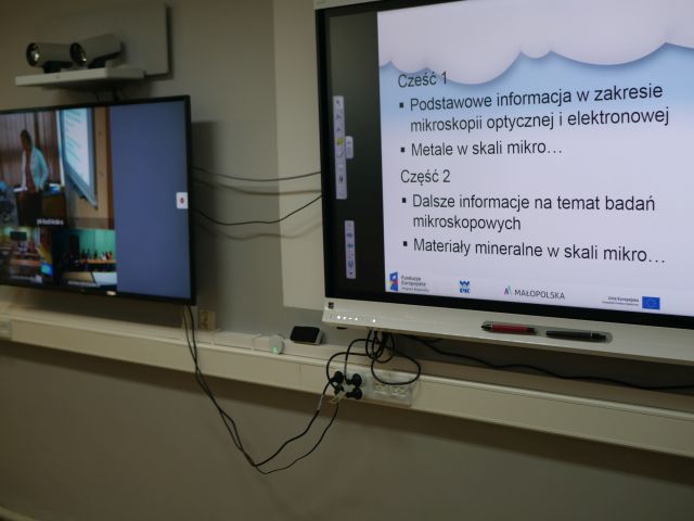 Zbliżenie na monitory; na jednym zdjęcie, na drugim treść wykładu