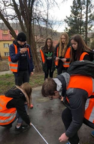 Uczniowie podczas pomiarów geodezyjnych