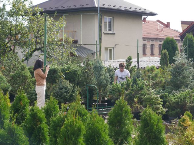 Dziewczyna fotografuje pracownika firmy Agrotechnik w trakcie wykonywania swoich obowiązków.