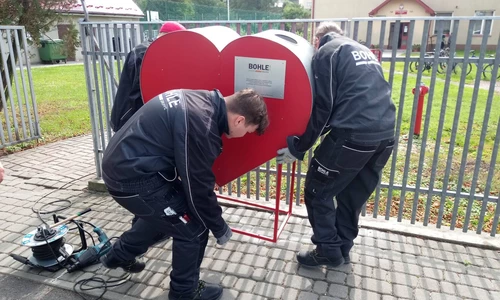 Uczniowie z instruktorem montują serce do zbierania nakrętek