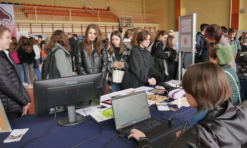 uczniowie przed stoiskiem szkoły